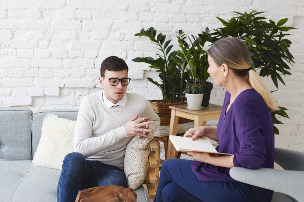 Young professional in therapy with an attentive Shieldmee clinician.